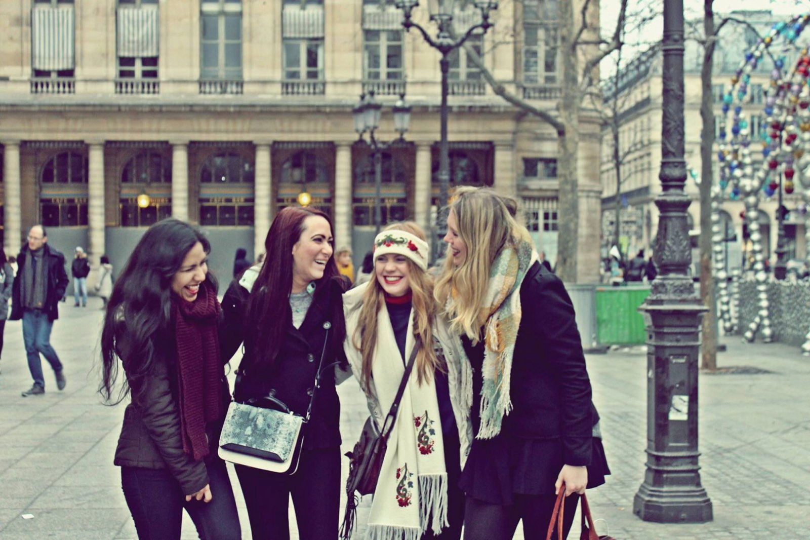 Au pair mexicana riendo con amigas de otros países en una plaza de París
